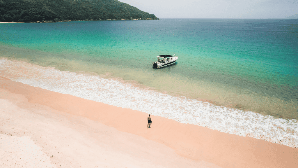 Scenic beach with turquoise waters and a boat in Brazil, featured in the Quito to Rio South America tour highlights.