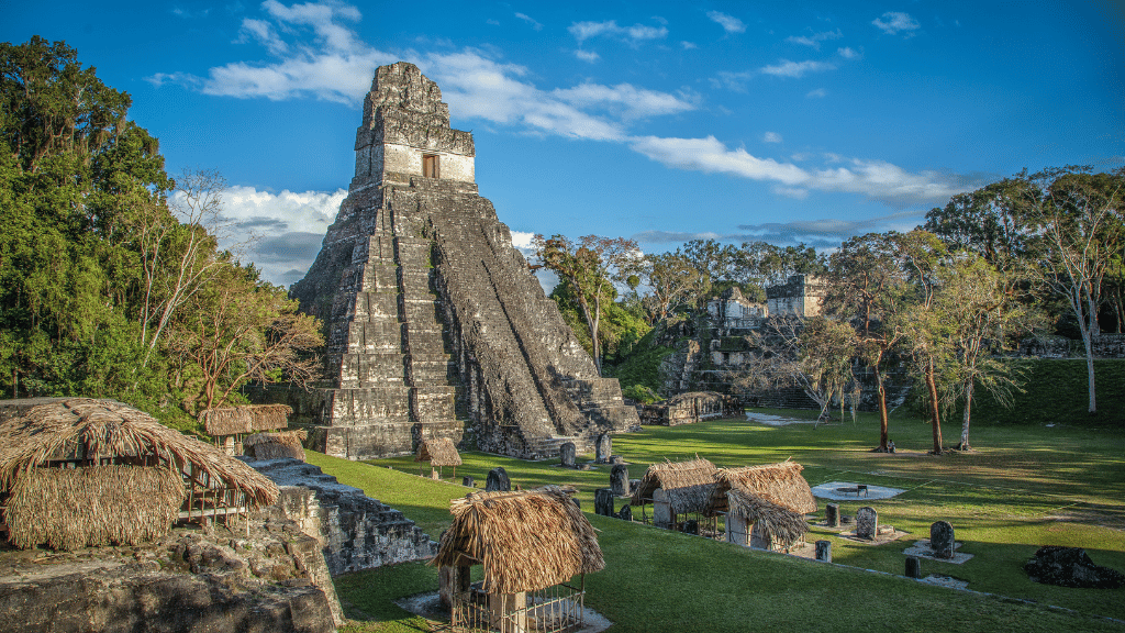 Ancient Mayan pyramid at Tikal under blue skies on the Maya Heartlands Tour - Adventure Ruins & Reefs | Highlights. A cultural and historical travel experience.