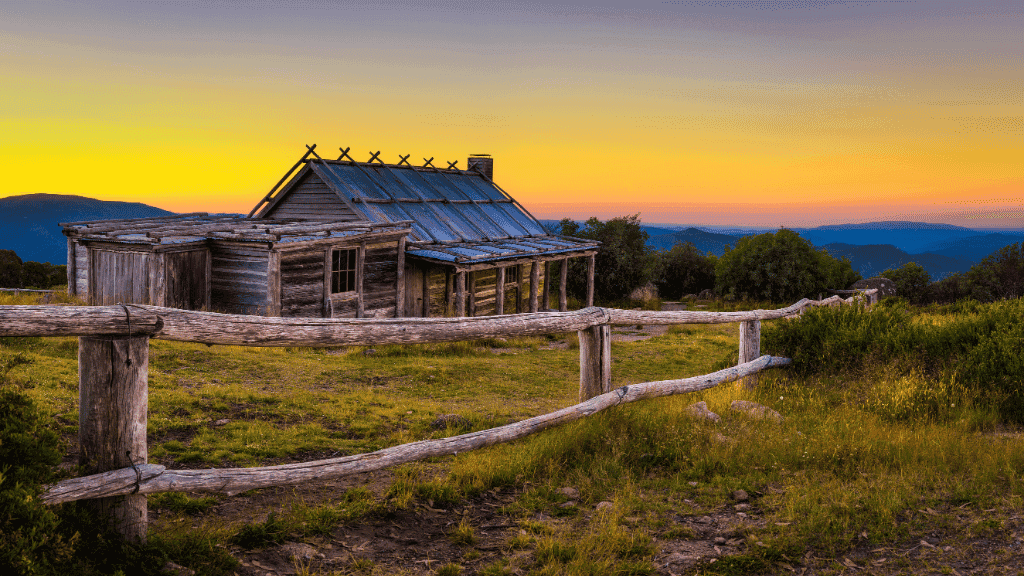 Rustic wooden hut at sunset in the Victorian Alps, part of the High Country Horizons 4 Day Walking Tour. Ideal for alpine lodge-style stays.
