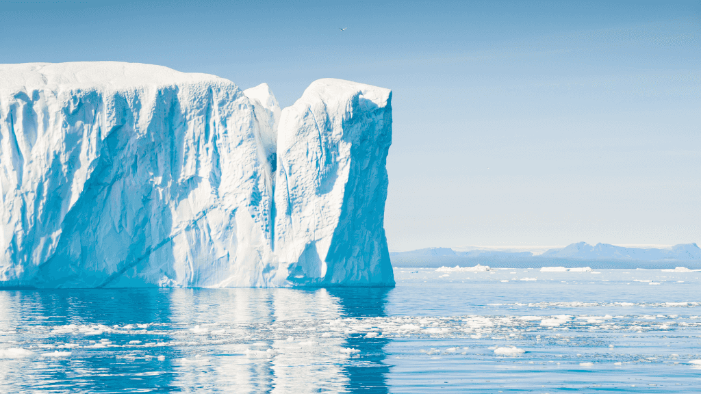 Massive iceberg floating in calm Arctic waters during the Atlantic Expedition Cruise - Iceland, Greenland, Labrador adventure.