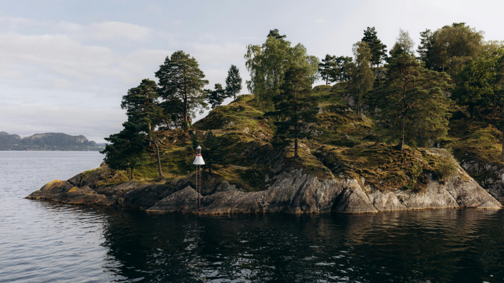 Rocky island with pine trees in a Northern Québec fjord. Scenic stop on the 7-day summer or winter adventure with outdoor activities.