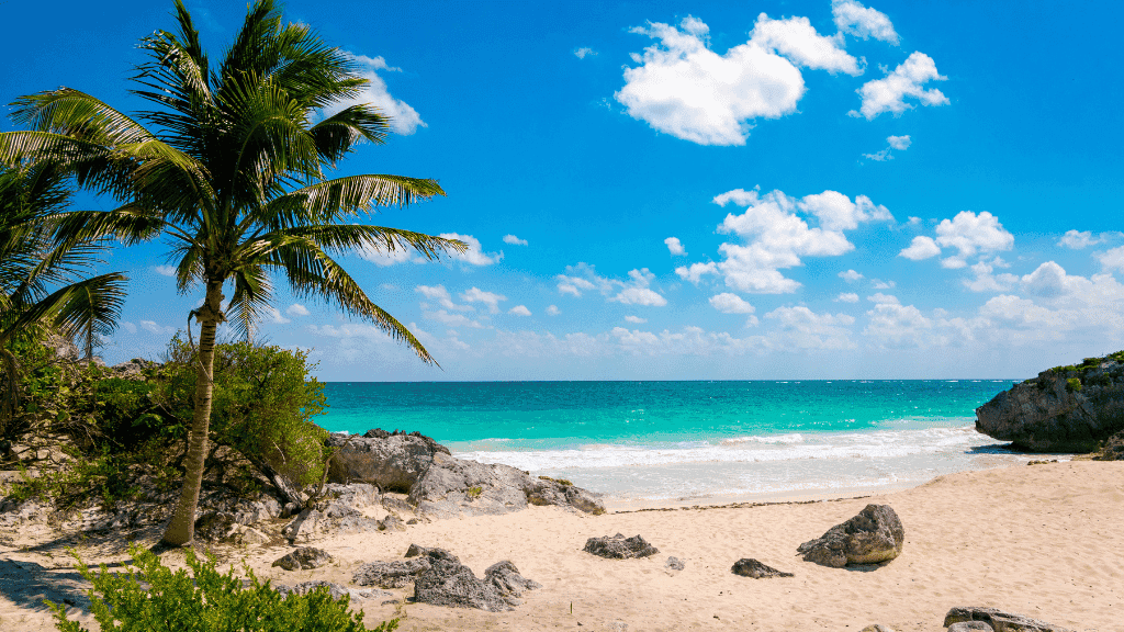 Tulum beach with turquoise waters and palm trees, featured in the Mexican Mayan Adventure - 14 or 22 Days coastal exploration.