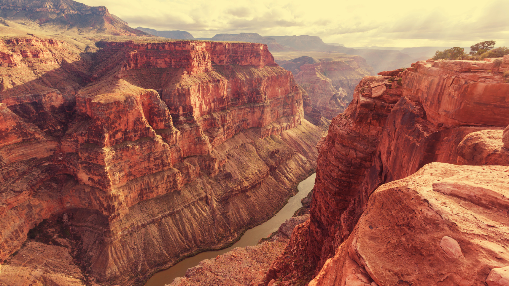 Grand Canyon view with layered red rock cliffs and winding Colorado River. Explore Western USA trips through iconic canyons and natural wonders.