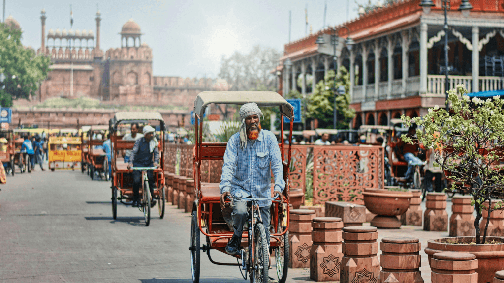 Rickshaw riders near Red Fort in Delhi on 12 Day India Cultural Tour - Palaces & Sacred Cities. Explore India's historic streets and landmarks.