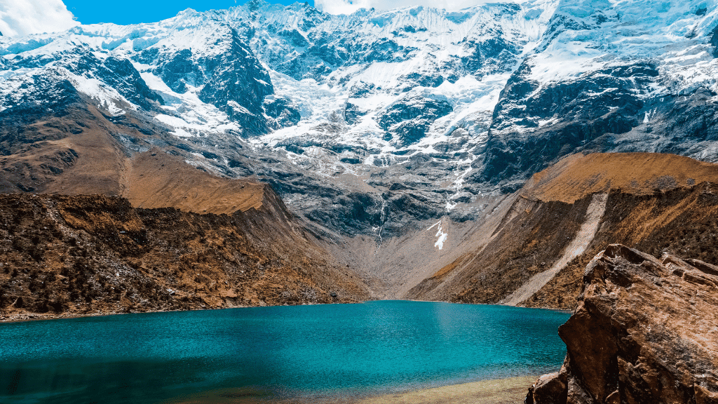 Turquoise lake beneath snowy Andes on Peru Adventure - Machu Picchu 14 Days | Small-Group Travel. High-altitude beauty for active explorers.