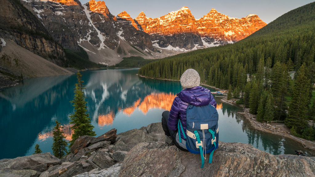 Backpacker overlooking Moraine Lake at sunrise during the Vancouver Calgary Rockies Tour - 14 Days | Scenic Travel. Ideal for active explorers.