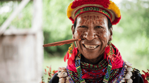 Quichua elder in traditional attire smiling during Amazon Homestay Adventure - Canoes, Cacao & More | Quichua Living cultural experience.