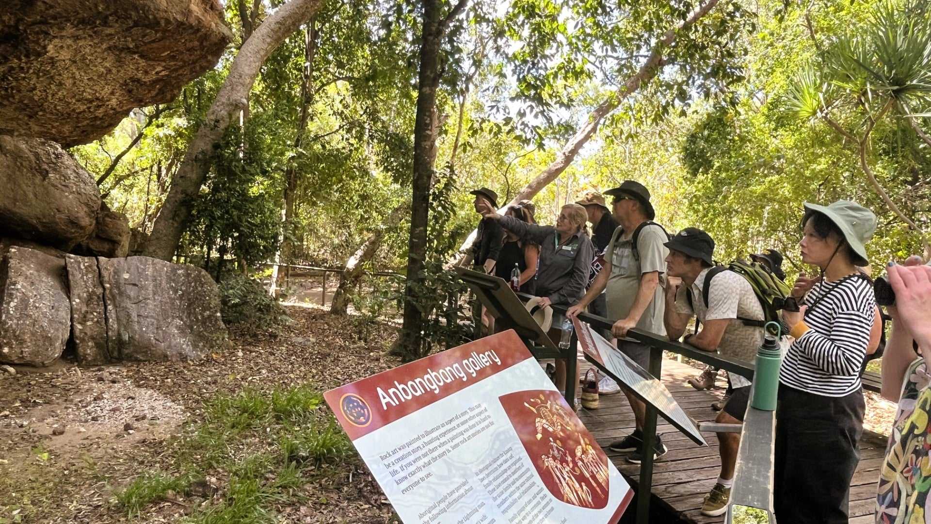 Group views Aboriginal rock art at Anbangbang Gallery on Kakadu Katherine Gorge Tour | 4-Day Comfort Travel. Guided cultural walk experience.