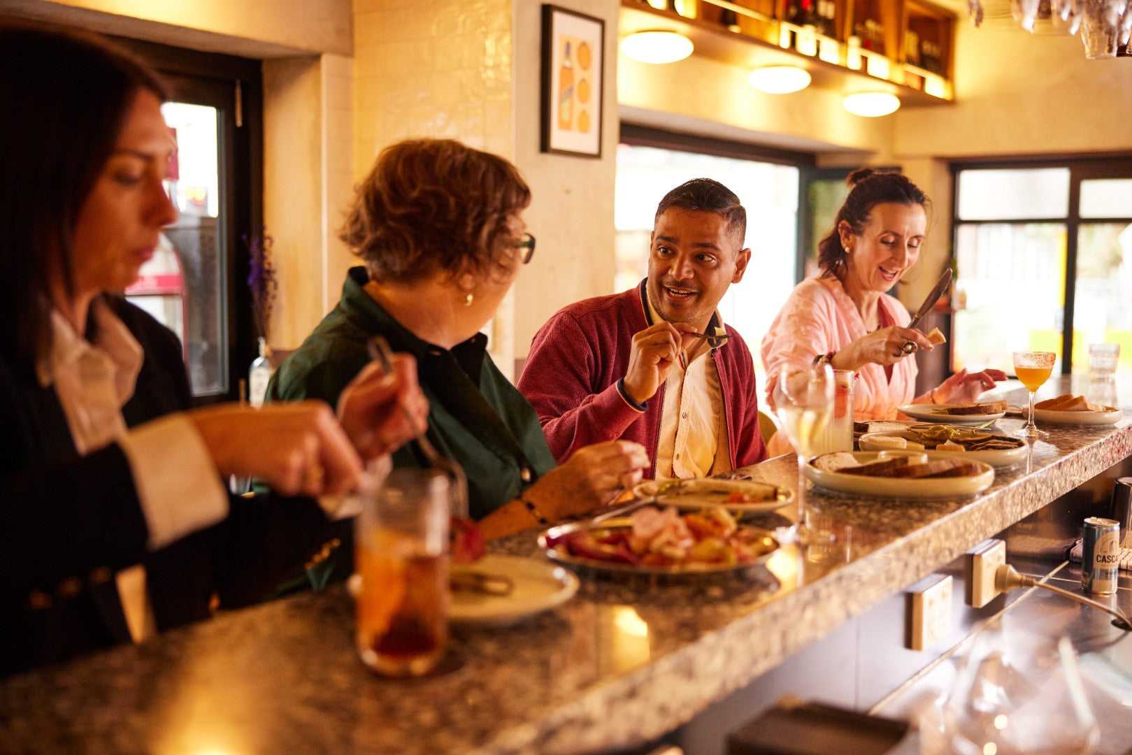 Travelers enjoy local cuisine at a cozy restaurant during the Whitsundays Reef Tour. Cultural dining experience on Brisbane to Cairns route.