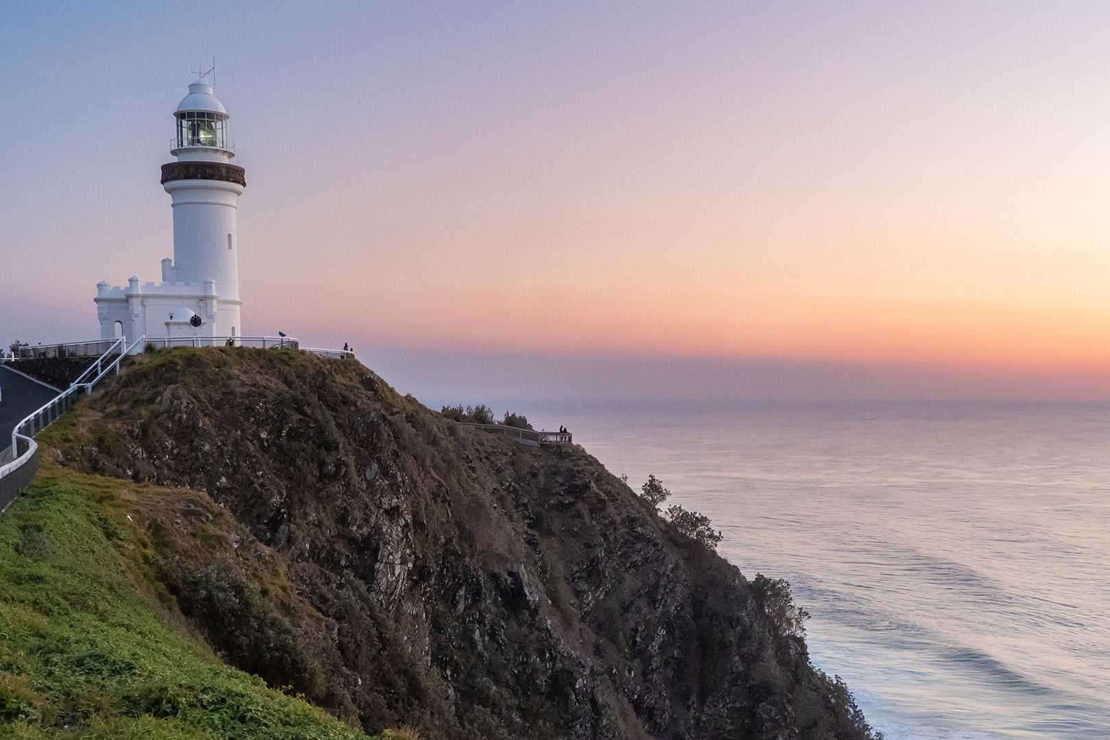 Cape Byron Lighthouse at dusk, scenic highlight on East Coast Australia tour. Coastal viewpoint on 8-day Sydney to Brisbane trip.