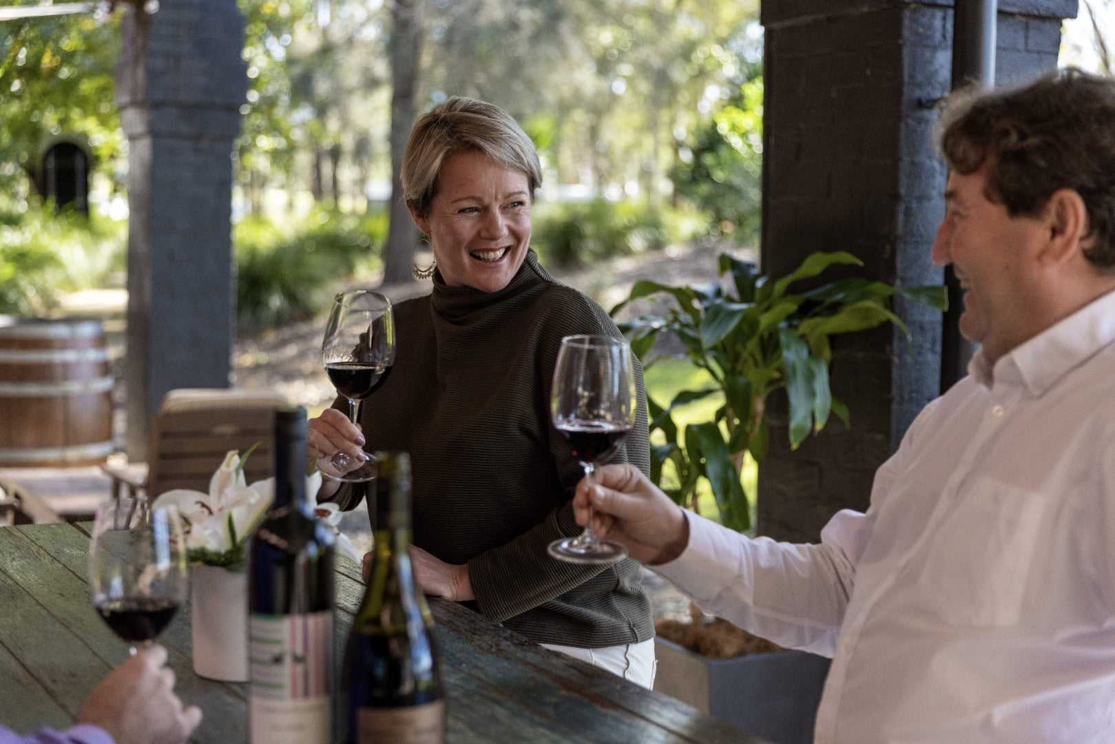 Travelers toasting wine at vineyard on East Coast Australia tour. Social experience on 8-day Sydney to Brisbane itinerary.
