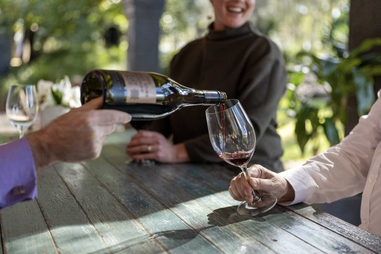 Wine being poured at vineyard table on East Coast Australia tour. Tasting experience on 8-day Sydney to Brisbane journey.