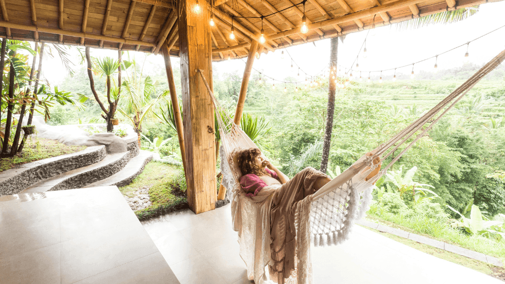Woman relaxing in a hammock overlooking Bali's rice terraces, showcasing Gili Slow-Life in Bali Komodo Lombok Tours - Explore Culture & Nature.