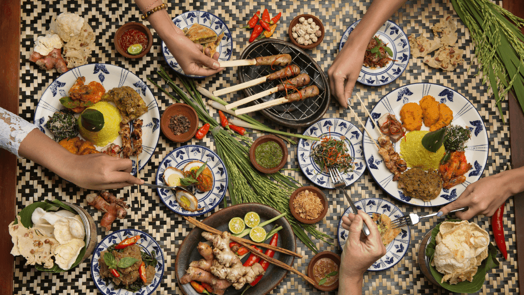 Traditional Balinese feast with satay and rice dishes, part of the cultural experience in Bali Komodo Lombok Tours - Explore Culture & Nature.