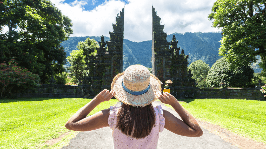 Traveler admiring Bali's iconic Handara Gate surrounded by lush greenery, featured in Bali Komodo Lombok Tours - Explore Culture & Nature.