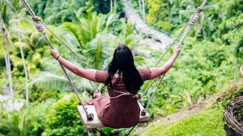 Woman on a jungle swing in Bali, enjoying nature as part of Bali Komodo Lombok Tours - Explore Culture & Nature.