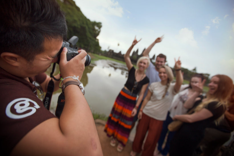 Group of tourists pose for a photo at Angkor Wat, enjoying the camaraderie of the Angkor to Islands 16-Day Tour - Khmer Culture to Thai Coasts.