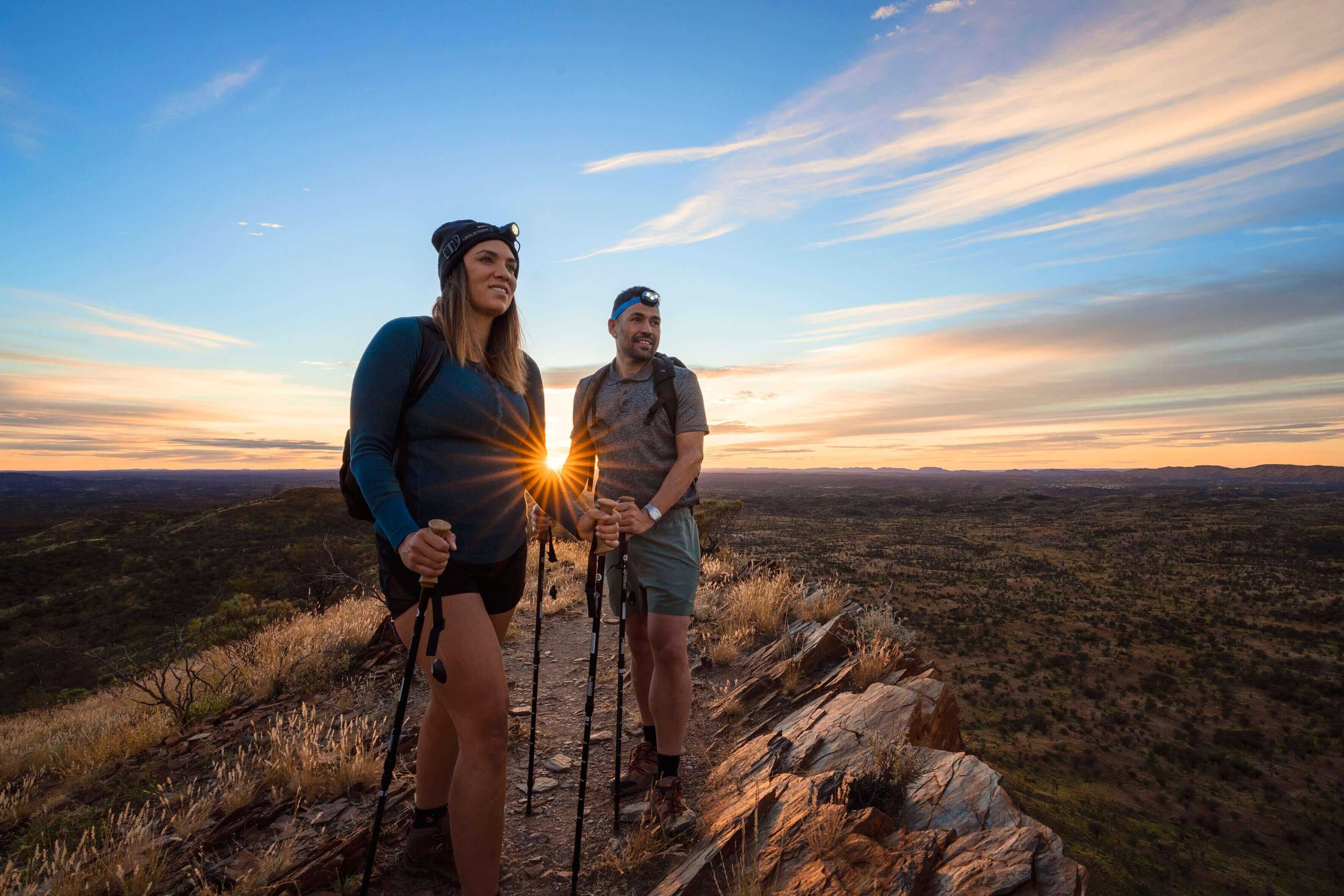 Hikers enjoying sunrise views on Larapinta Trail 5-Day Expedition, showcasing scenic trekking in West MacDonnell Ranges.
