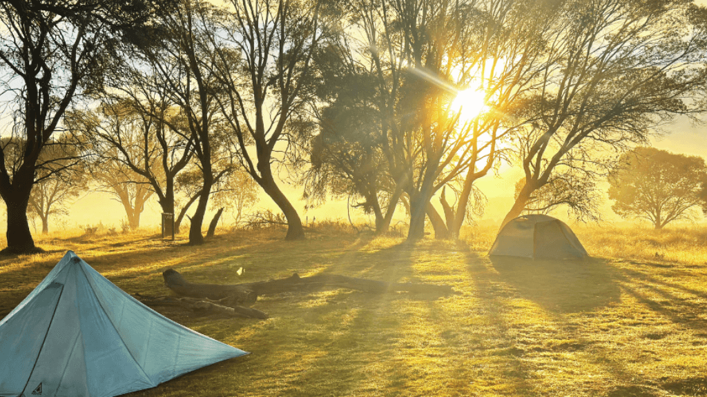 Sunrise over tents in Mt Bimberi & Blue Waterholes - Tour Adventure campsite. Ideal for 4-day wilderness camping and outdoor exploration in Australia.