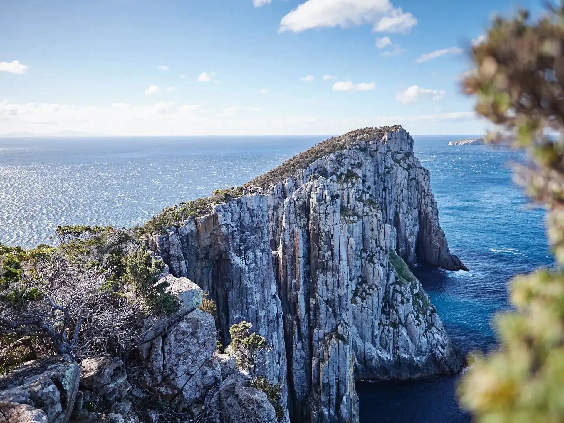 Rocky cliff overlooking the ocean with a clear blue sky