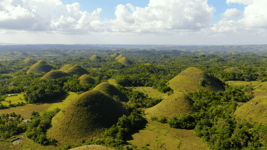 Daytime view of Bohol’s Chocolate Hills, a natural wonder in Philippines Travel Tours - Icons of the Philippines | 10/14/23 Days.