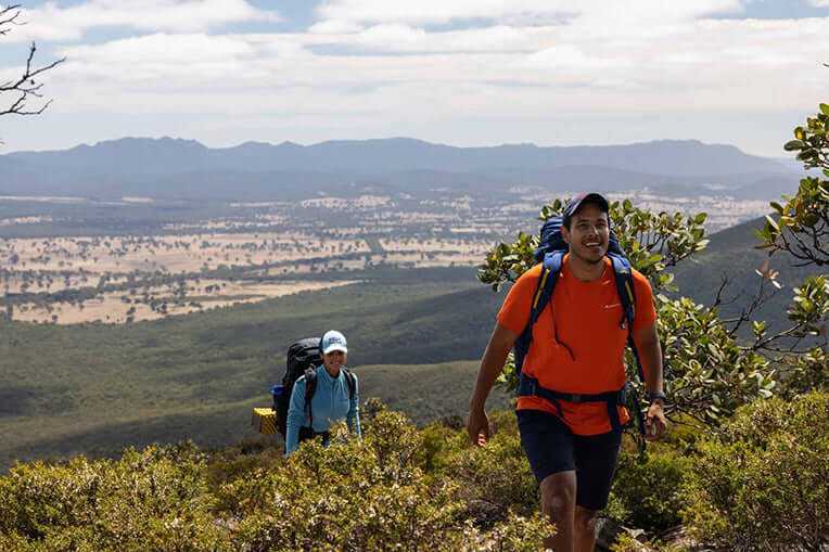 Hikers ascend a trail with panoramic views of the Southern Grampians during the 5-Day Grampians Expedition from Jimmy Creek to Dunkeld.