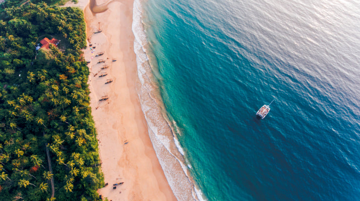 Aerial view of tropical beach and catamaran in Sri Lanka. Explore Sri Lanka - Land & Sea Tour Options includes coastal sailing and beach time.
