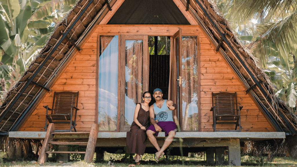 Couple relaxing at a wooden A-frame lodge, part of the unique accommodations on the 12-day Sri Lanka spice and coast tour.