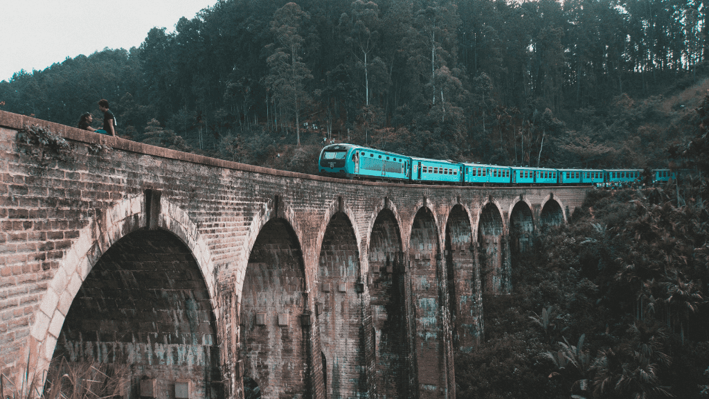 Train crossing the iconic Nine Arches Bridge in Sri Lanka, a scenic highlight of the 12-day spice gardens and coast tour.
