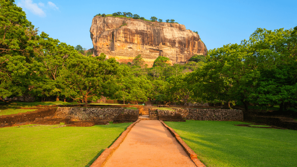 Path leading to Sigiriya rock fortress surrounded by greenery, a cultural landmark on the Sri Lanka 12-day tour itinerary.