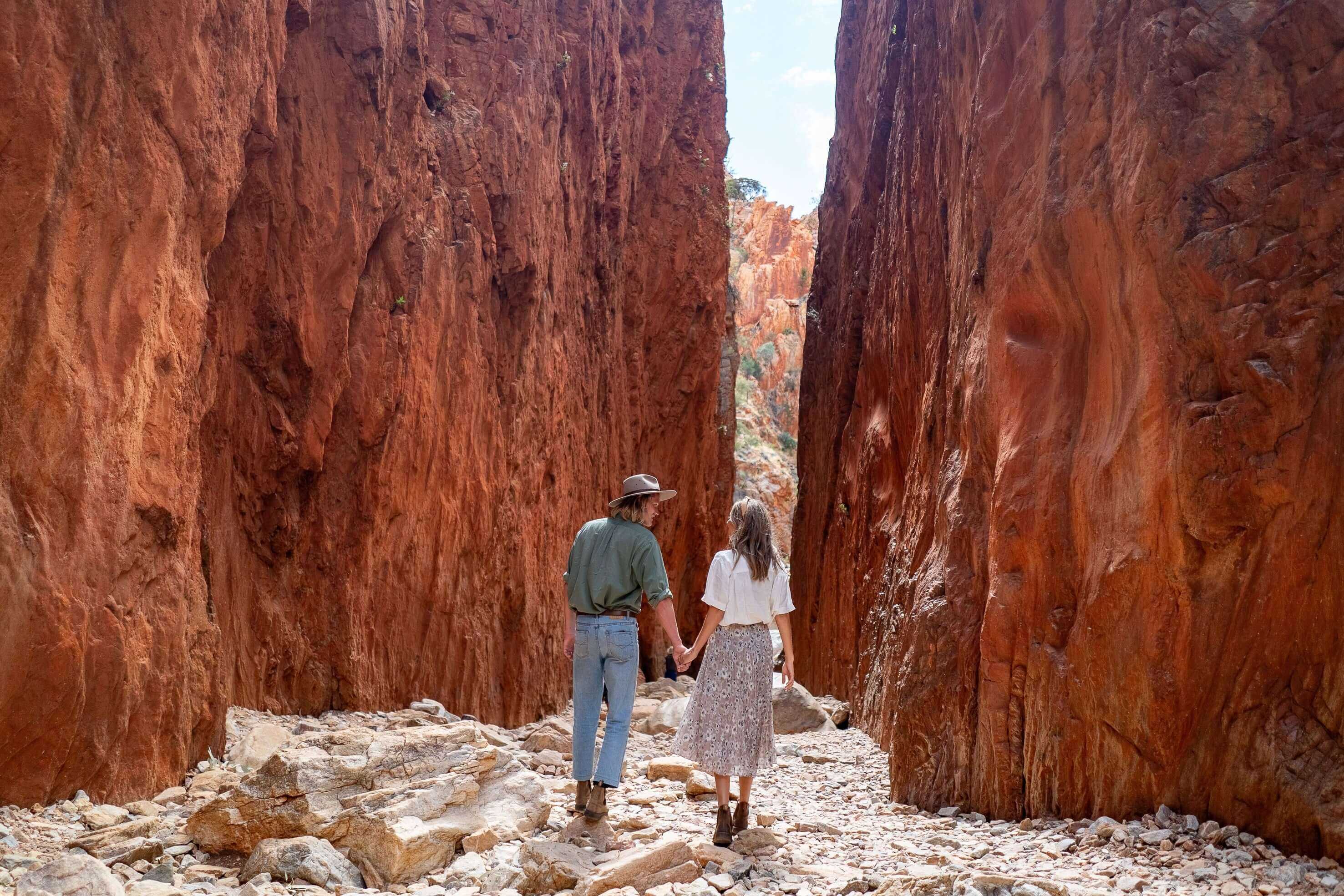 Couple holding hands in Standley Chasm, a key Aboriginal site on Larapinta Trail 5-Day Expedition in West MacDonnell Ranges.