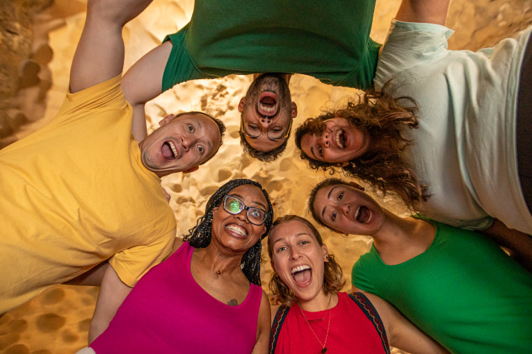 Group huddled in a cave smiling at the camera during Vietnam tour. Fun group moment on Vietnam Hiking and Cycling Tour.
