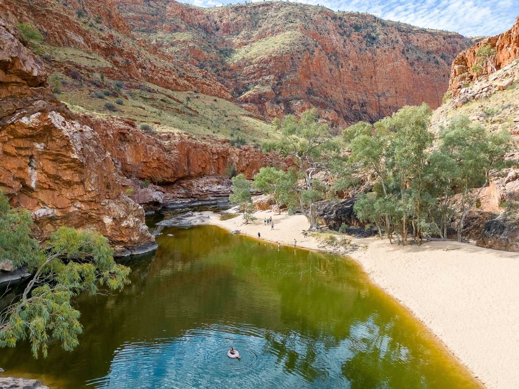Ormiston Gorge waterhole surrounded by red cliffs, a scenic rest stop on the Larapinta Trail 5-Day Expedition in Australia.