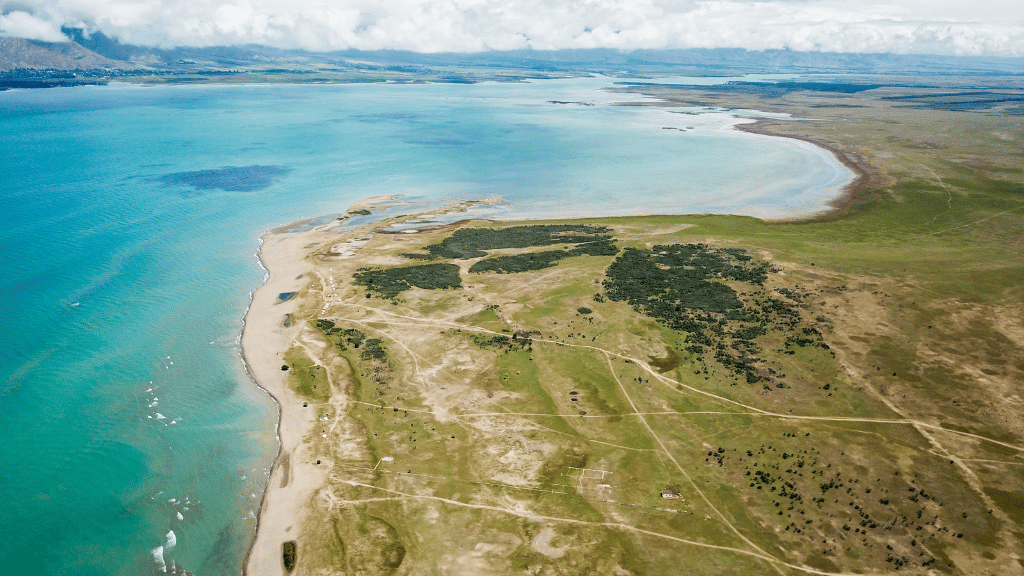 Aerial view of Issyk-Kul Lake’s shoreline in Kyrgyzstan, a natural gem on the 14-23 Day Central Asia Silk Road Tour.