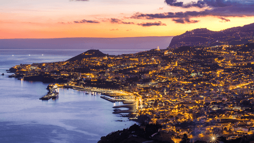 Funchal city lights at sunset viewed from above, a scenic stop during the 6-days hiking Madeira’s trails adventure.