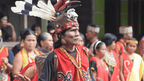 Dayak tribesman in traditional attire during cultural event, part of Borneo orangutan and heritage tour experience.