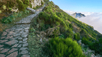 Stone hiking path along a green mountain slope in Madeira, part of the 6-days hiking Madeira’s trails route.