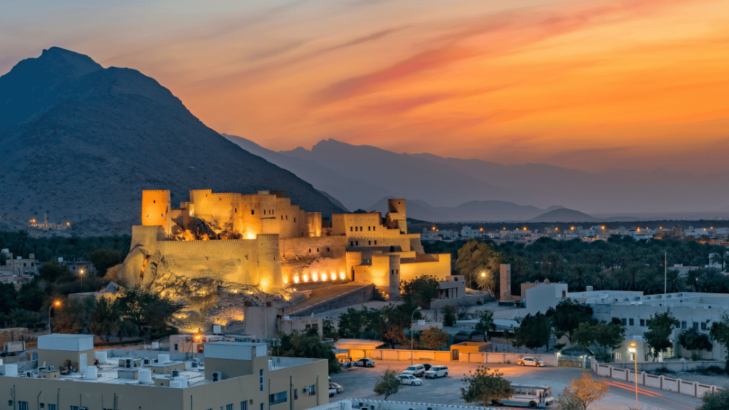 Sunset over Nizwa Fort with Al Hajar Mountains in the background, part of Oman 8 Day Adventure - Desert Stars & Turtle Shores tour highlights.