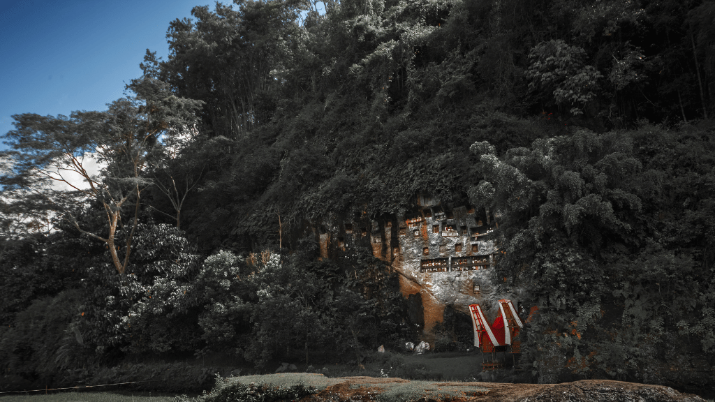 Cliffside burial site with traditional Torajan structures, a key cultural site on the Soul of Sulawesi - Tana Toraja Culture Tour.