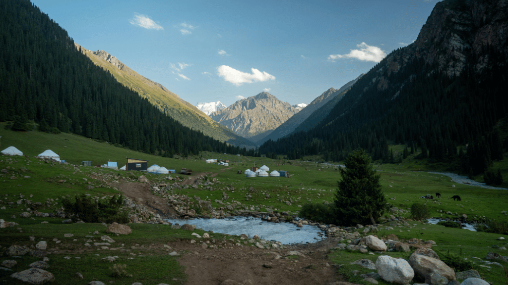 Yurt camp nestled in a forested Kyrgyz valley, offering immersive stays on the 14-23 Day Central Asia Silk Road Tour.