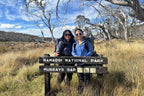 Two hikers at Murrays Gap sign in Namadgi National Park, starting point for Mt Bimberi & Blue Waterholes tour adventure.