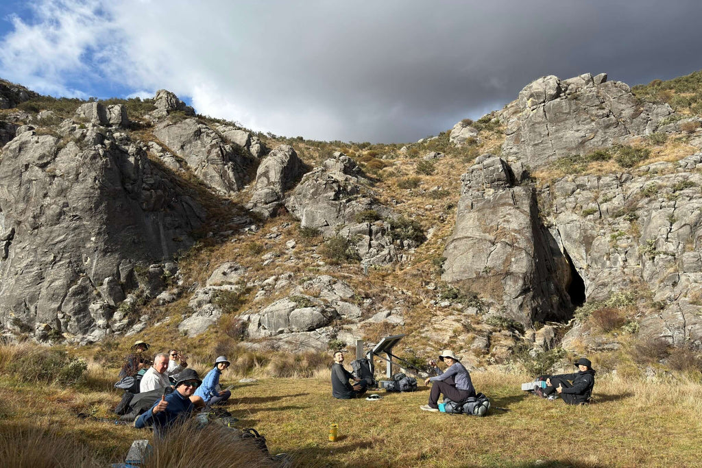 Group resting near rocky cliffs during Mt Bimberi & Blue Waterholes wilderness tour in Namadgi National Park.