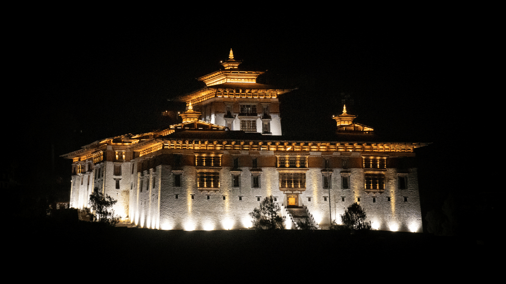 Illuminated dzong at night along the Trans Bhutan Trail, showcasing Bhutanese architecture during hotel stays.