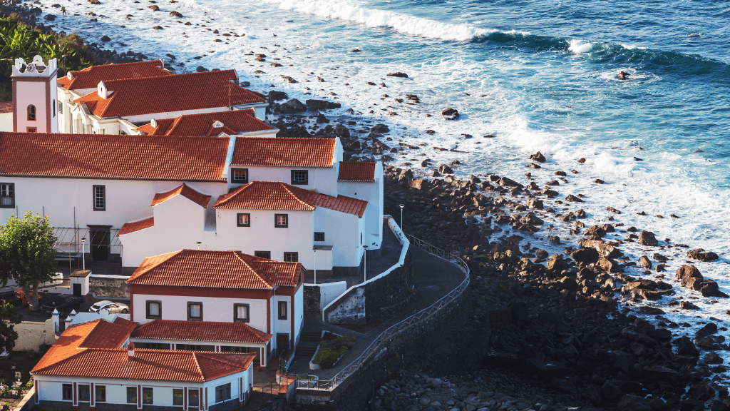 Traditional white houses with red roofs on Madeira’s rocky coast, seen during the 6-days hiking Madeira’s trails tour.