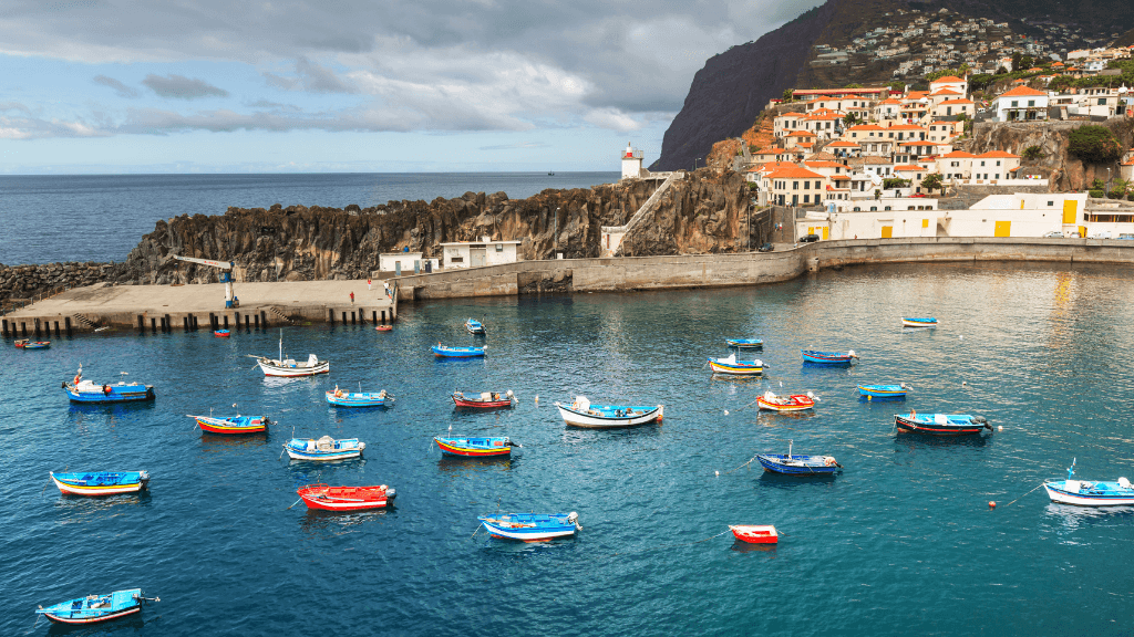 Colorful fishing boats in a Madeira harbor, a cultural highlight of the 6-days hiking Madeira’s trails experience.