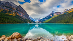 Lake Louise with turquoise water, rocky shore, and snow-capped mountains.