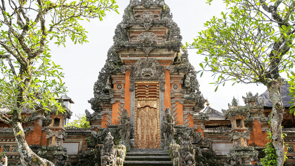 Ornate Balinese-style temple gate surrounded by trees, a spiritual stop on the Soul of Sulawesi - Tana Toraja Culture Tour.