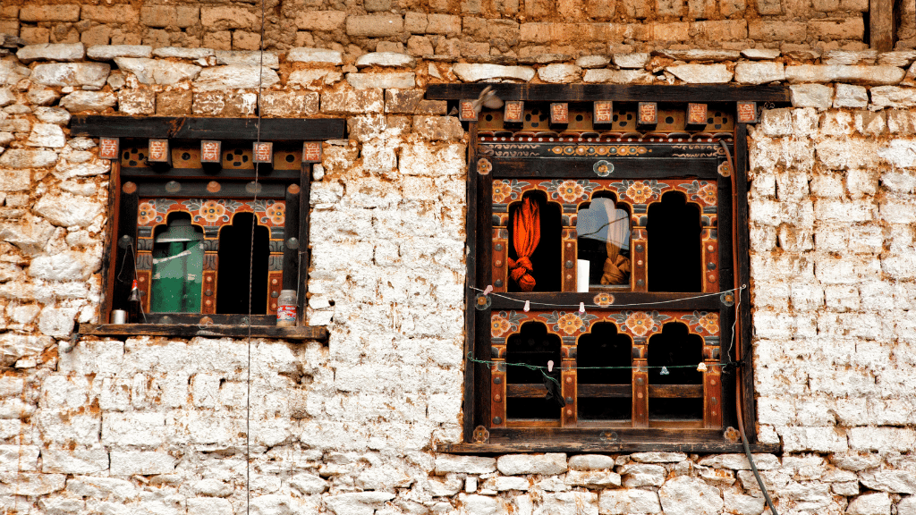 Decorative wooden windows on a traditional Bhutanese home, seen during village visits on the Trans Bhutan Trail.