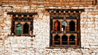 Decorative wooden windows on a traditional Bhutanese home, seen during village visits on the Trans Bhutan Trail.
