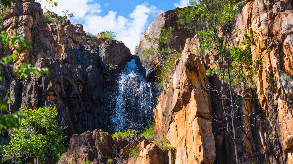 Breathtaking waterfall cascading down rocky cliffs in Australia's Top End, showcasing nature's beauty and adventure.